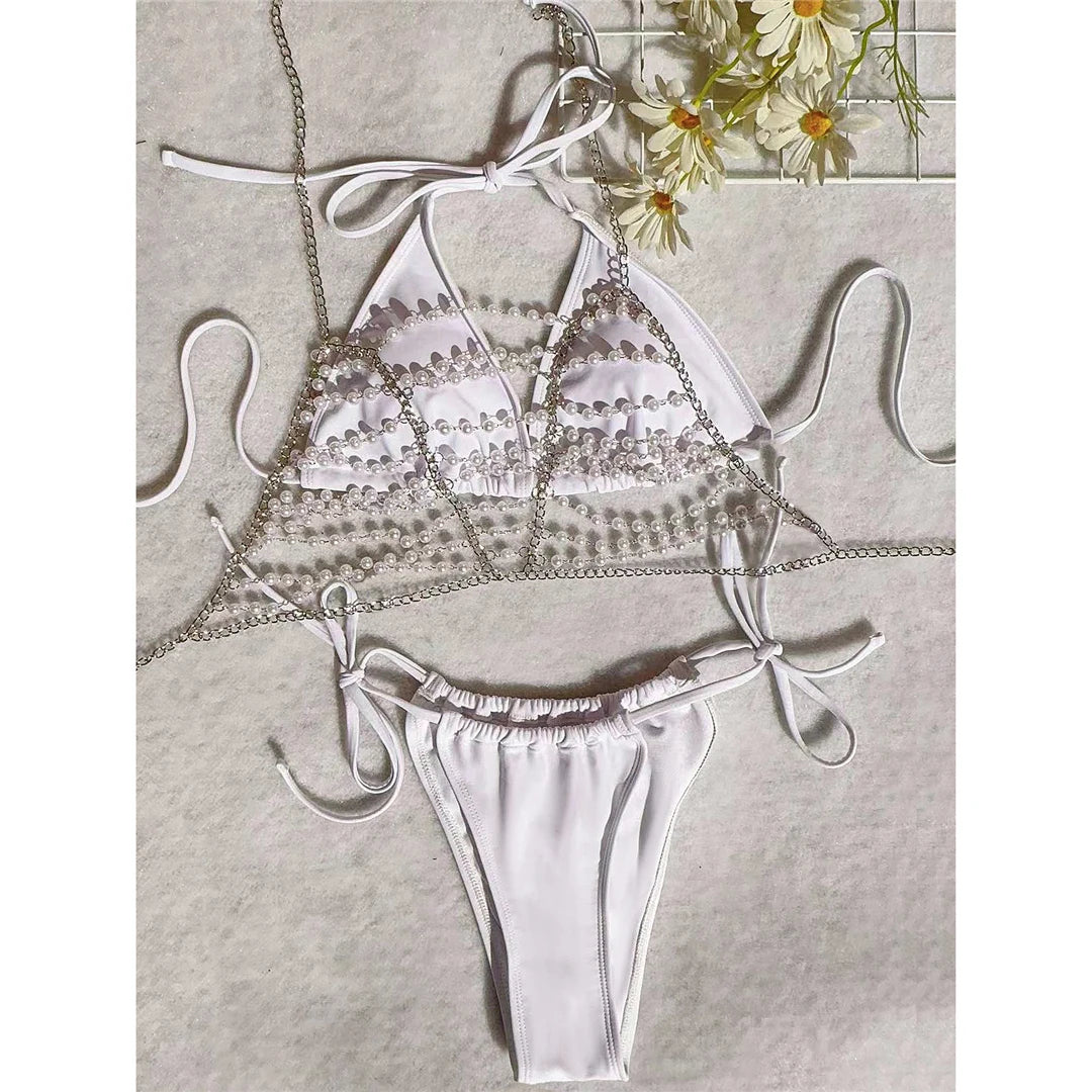 Halter Bikini Set in White Adorned with Delicate Pearls and Shimmering Metal Chains, Three Piece Swimwear for Women. Made from Nylon and Spandex. Solid Pattern and True to Size. Features Low Waist, Wire Free Support, and Padding. Sizes Available: S, M, L.
