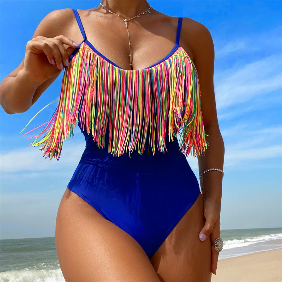 Women's Colorful Fringe Tassel One Piece Swimsuit with Cut Out Design and High Leg Cut. Made from Nylon and Spandex, Fits True to Size. This Solid Pattern Swimsuit is Available in Sizes S, M, L and in Colors Blue Hot Pink, Blue, Hot Pink, and Multicolor. Features a Daring V-Neck and Dynamic Fringe Detail for a Vibrant Poolside Look.