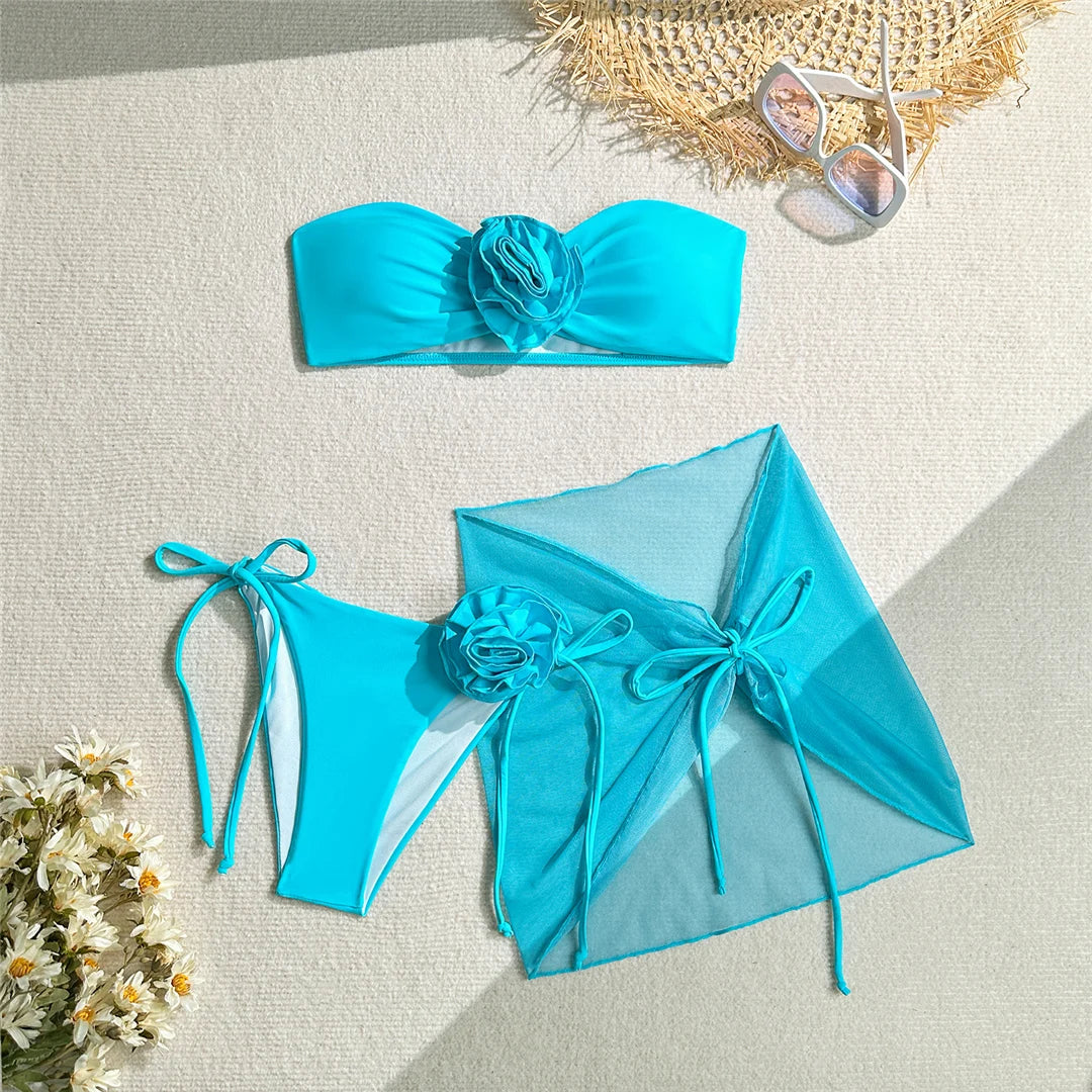 Eleganter 3D-Blumen Bandeau-Bikini mit Sarong, dreiteilige Damen-Bademode in Pink, Lila und Blau, aus weichem Nylon und Spandex, drahtlose Unterstützung mit Polsterung, mit niedriger Taille und größengetreuer Passform. Verfügbare Größen: S, M, L.