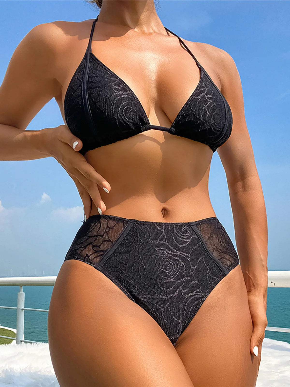 Intricately embroidered halter bikini set in black for women. Features a mid-waist cut for comfort and style, made from Nylon and Spandex. Offers wire free support and fits true to size. This elegant two-piece solid bikini comes with a pad. Available in sizes XS, S, M, and L. Free shipping on this modern swimwear, fit for women aged 18 to 35.