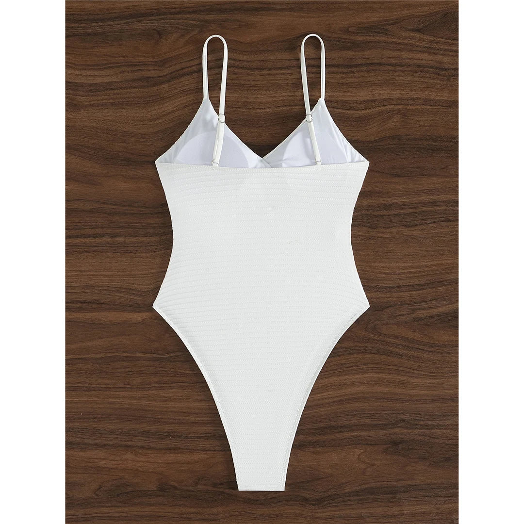 Ribbed V neck one piece swimsuit in solid white with wrinkled texture and high cut design for a chic and elegant beach look.
