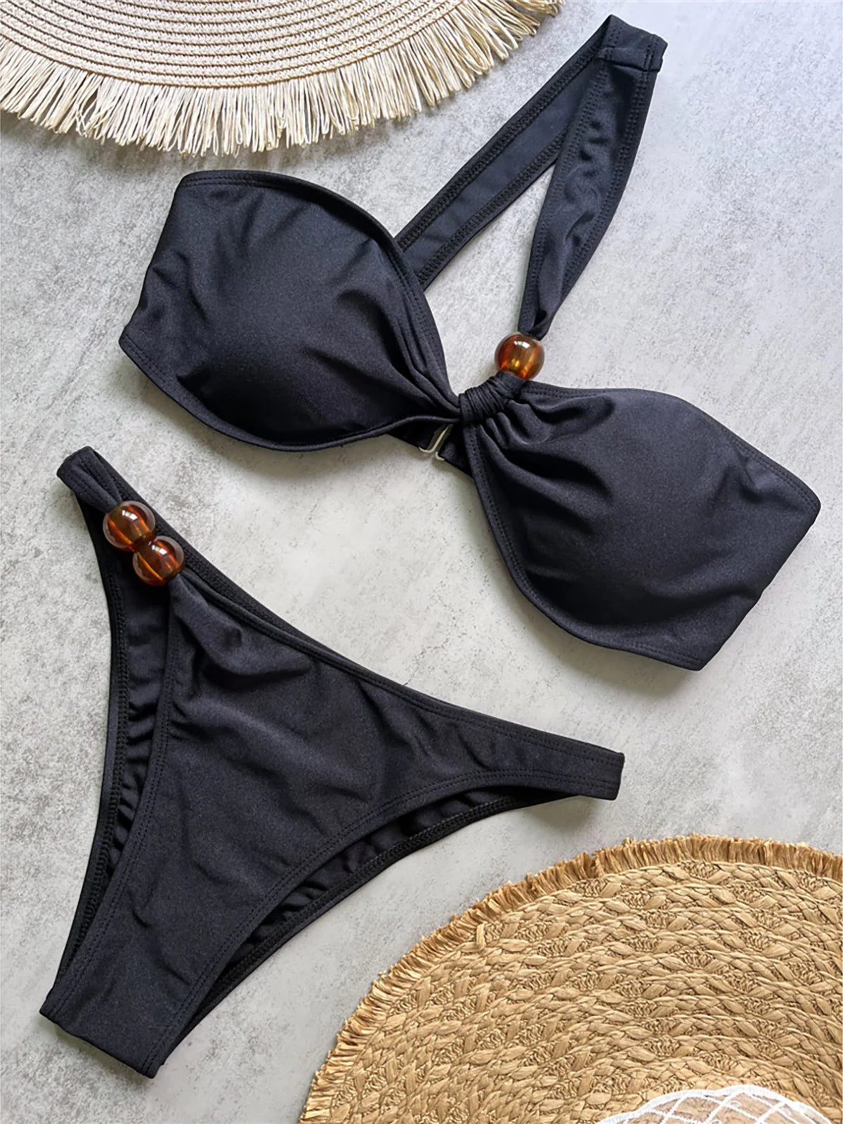 One shoulder high cut bikini set with asymmetrical design and solid color for a chic and modern beach look in brown, black, or white.