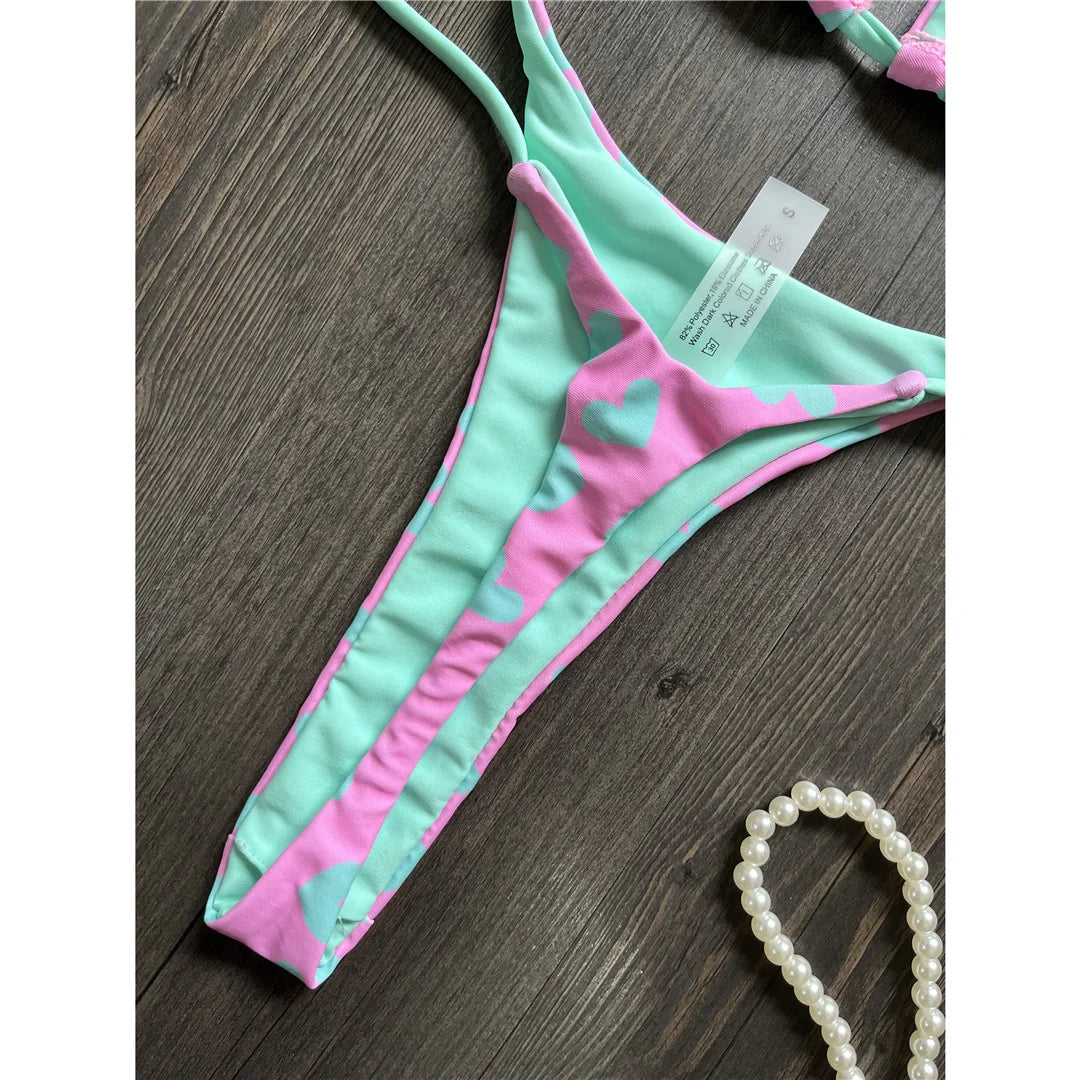 Feiern Sie den Sommer mit unserem Love Printed Extreme Mini-Tanga-Bikini-Set in Weiß-Schwarz, Weiß, Schwarz, Lila-Grün, Lila, Grün und Multicolor. Diese gewagte zweiteilige Bademode aus Nylon und Elasthan ist für Mutige gedacht und passt genau auf die Größe. Dieses kabellose Bikini-Set mit niedriger Taille und auffälligem "Love"-Druck hat einen Ultra-Mini-Schnitt und wird mit einem Polster geliefert. Perfekt für Frauen, die am Pool oder am Strand ein Statement setzen wollen.