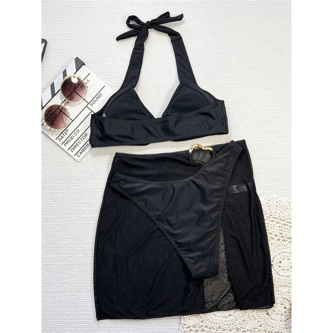 Chic halter bikini three-piece set with Brazilian cut and matching skirt in solid black, crafted from polyester and spandex.