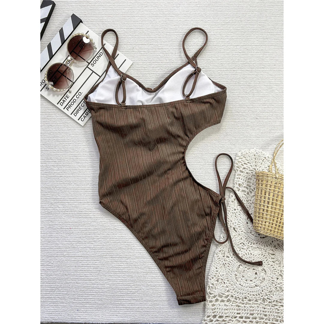 Asymmetric cut-out lace-up one piece swimsuit in solid coffee color with wrinkled texture and high cut design for a bold, modern look.