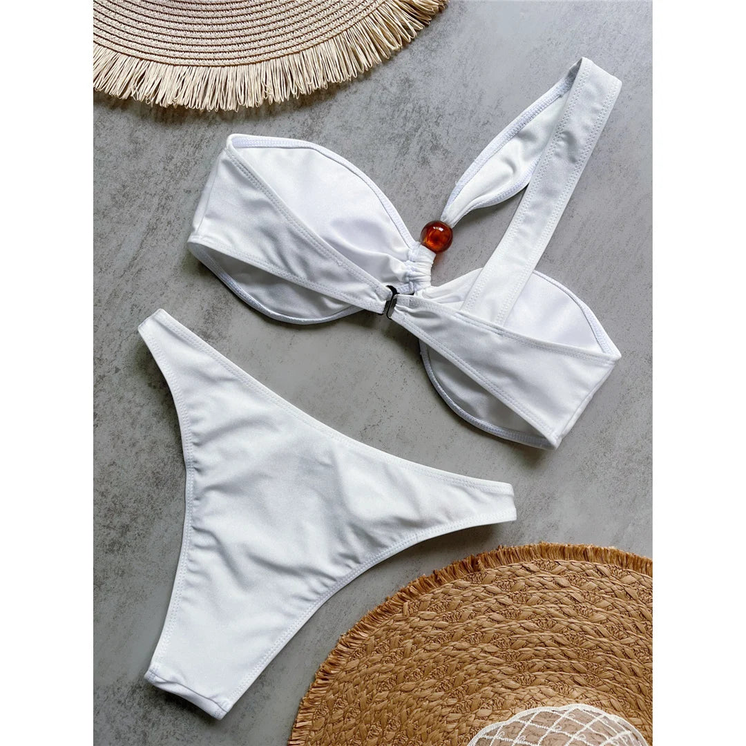 One shoulder high cut bikini set with asymmetrical design and solid color for a chic and modern beach look in brown, black, or white.
