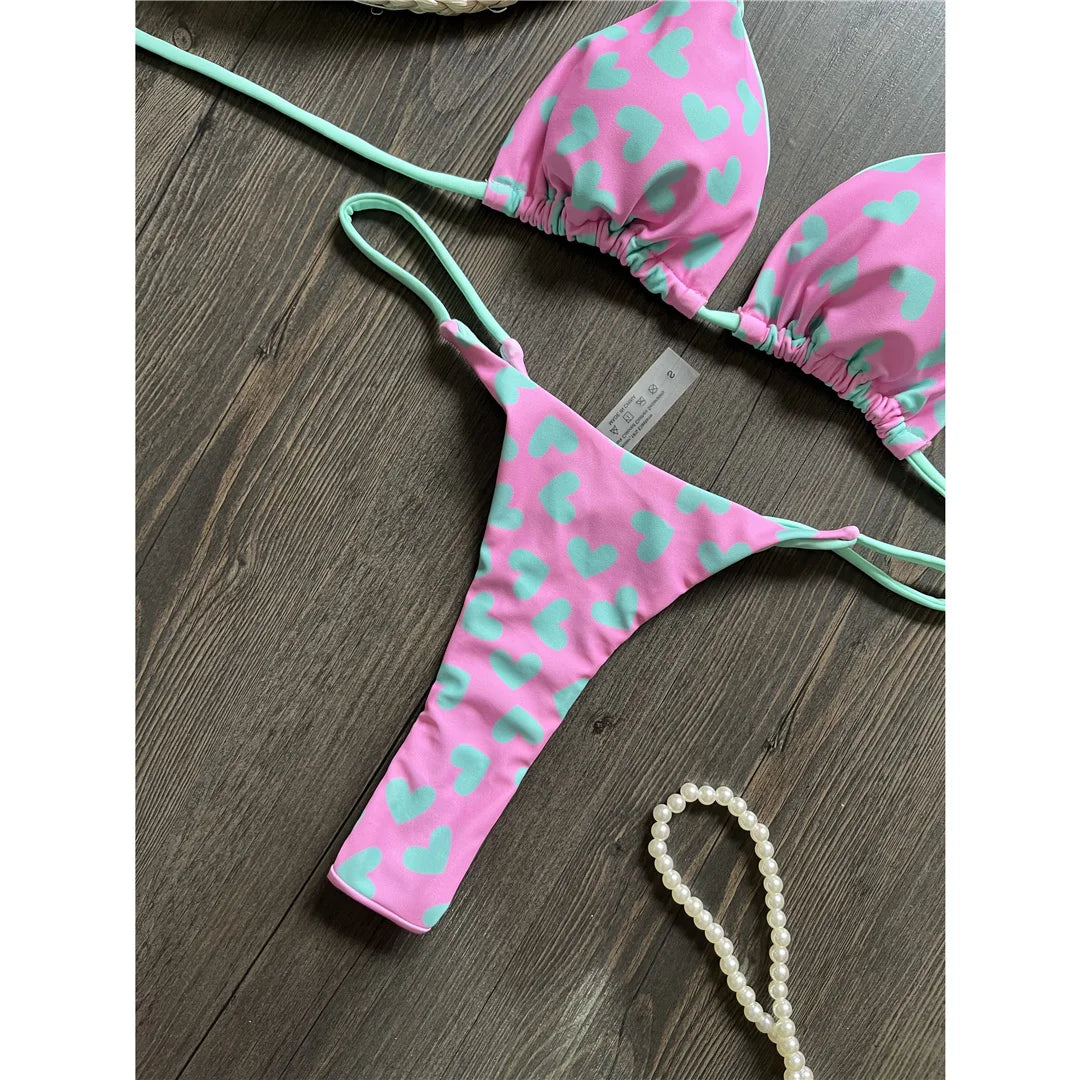 Célébrez l'été avec notre ensemble de mini-bikini string extrême imprimé Love en blanc, noir, blanc, noir, violet, vert, violet, vert et multicolore. Ce maillot de bain deux pièces audacieux, en nylon et spandex, est conçu pour les audacieuses et s'adapte à la taille. Doté d'un imprimé "Love" accrocheur et d'une coupe ultra-mini, cet ensemble de bikini sans fil et à taille basse est livré avec un coussinet. Il est parfait pour les femmes qui veulent se faire remarquer au bord de la piscine ou à la plage.