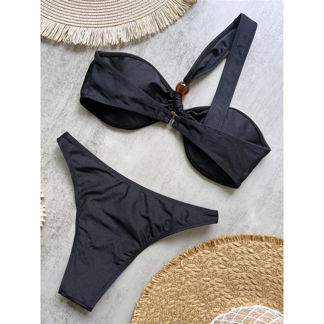 One shoulder high cut bikini set with asymmetrical design and solid color for a chic and modern beach look in brown, black, or white.