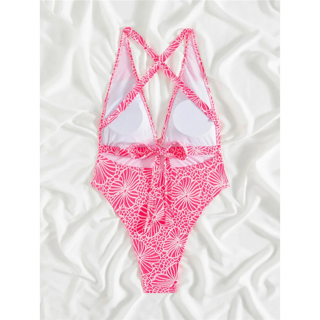 Printed deep V-neck cross back one-piece swimsuit with high-leg cut for an elegant beach look for women.