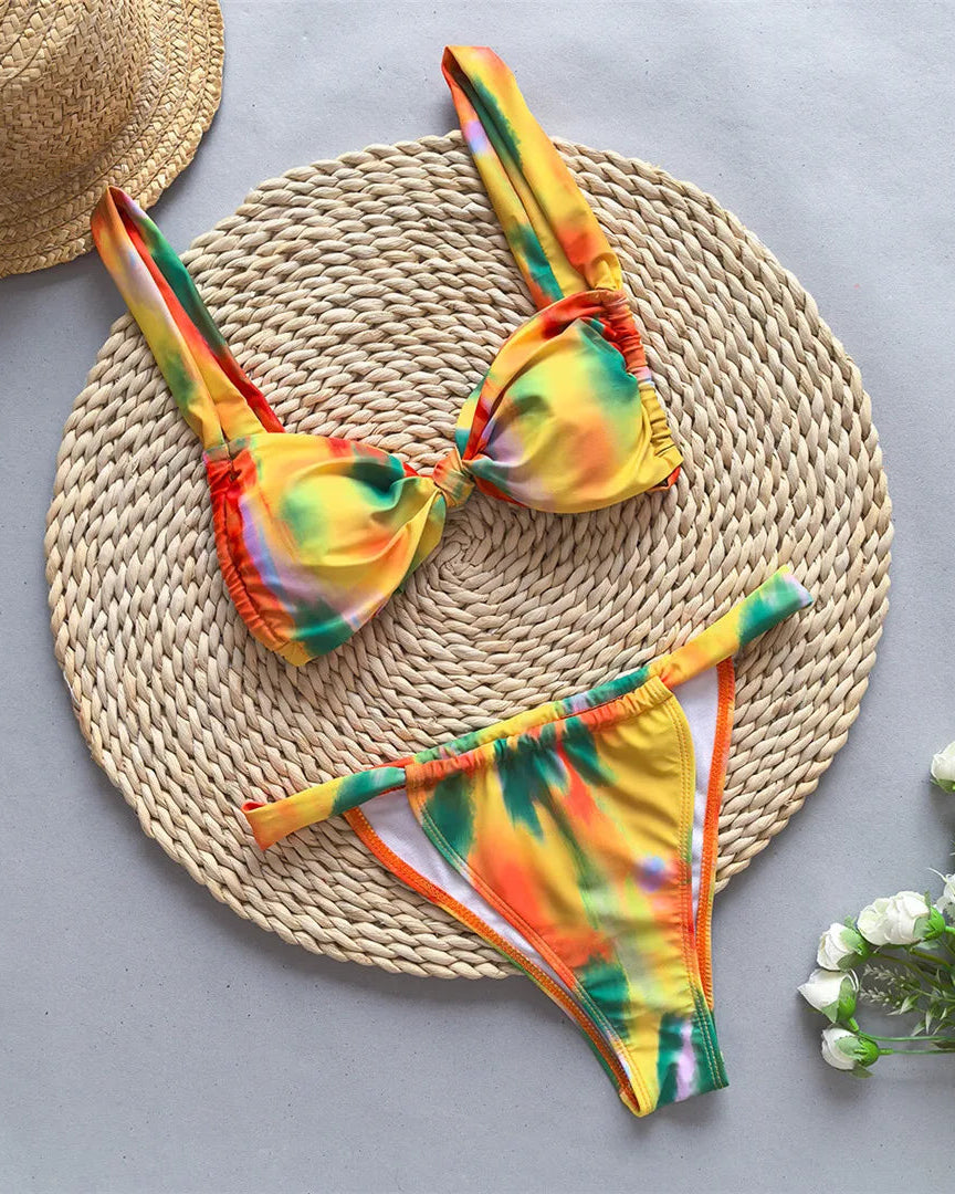 Tie dye flowers bikini set with floral accents and high leg cut in green, orange, and yellow.