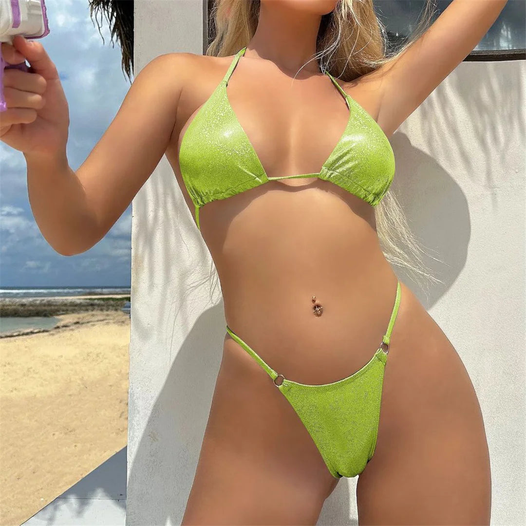 Scintillante set bikini con taglio alto e cavezza disponibile in viola, bianco, arancione, verde neon, rosa, azzurro e blu neon. Un due pezzi di grande effetto, realizzato in nylon e spandex, con vita bassa e supporto senza fili. Veste la taglia giusta, perfetto per le donne che vogliono brillare durante le loro vacanze in spiaggia.