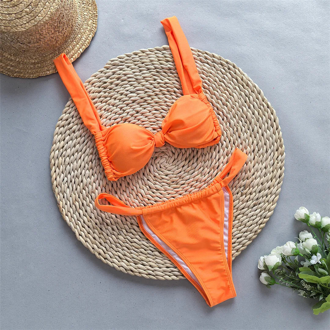 Tie dye flowers bikini set with floral accents and high leg cut in green, orange, and yellow.