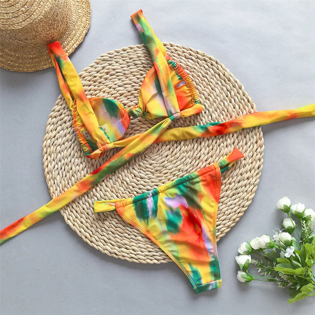 Tie dye flowers bikini set with floral accents and high leg cut in green, orange, and yellow.