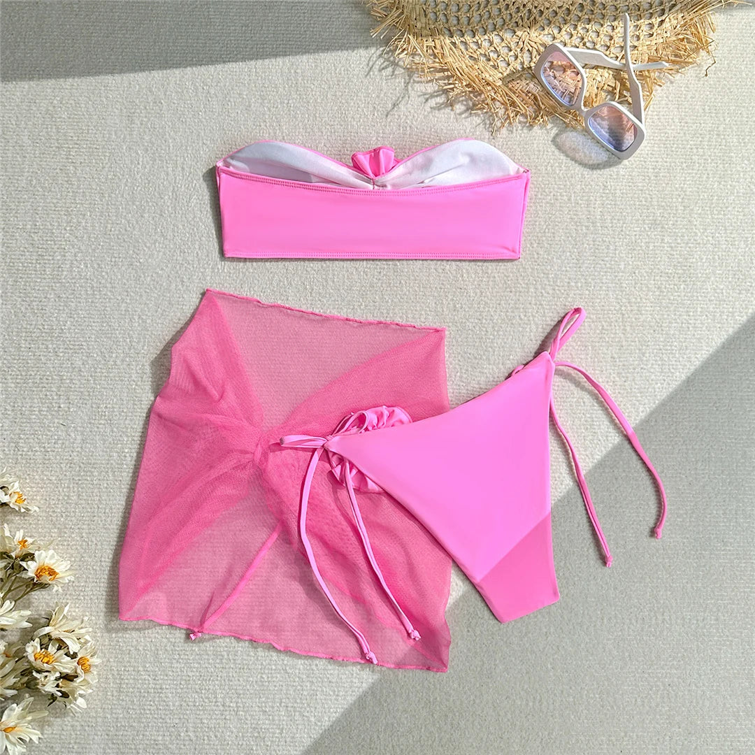 Elegante bikini a fascia con fiori 3D e pareo, costume da bagno tre pezzi da donna in rosa, viola e blu, realizzato in morbido nylon e spandex, supporto senza fili con imbottitura, fondo a vita bassa e vestibilità regolare. Taglie disponibili: S, M, L.