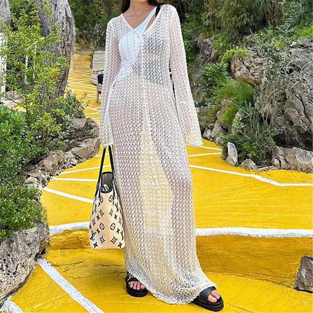 Elegant long sleeve crochet tunic beach cover-up, ideal for seaside styling. Features a delicate see-through design, crafted from a mix of nylon, polyester, rayon, and cotton. True to size, available in white.