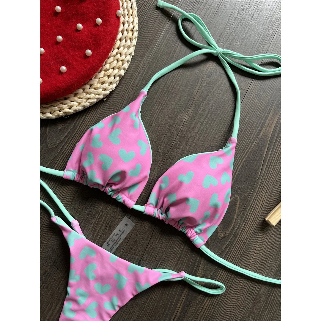 Celebrate summer with our Love Printed Extreme Mini Thong Bikini Set in white black, white, black, purple green, purple, green, and multicolor. This daring two-piece swimwear, made from nylon and spandex, is designed for the bold and fits true to size. Featuring an eye-catching 'Love' print and an ultra-mini cut, this wire-free and low waist bikini set comes with a pad. Perfect for women looking to make a statement by the pool or at the beach.