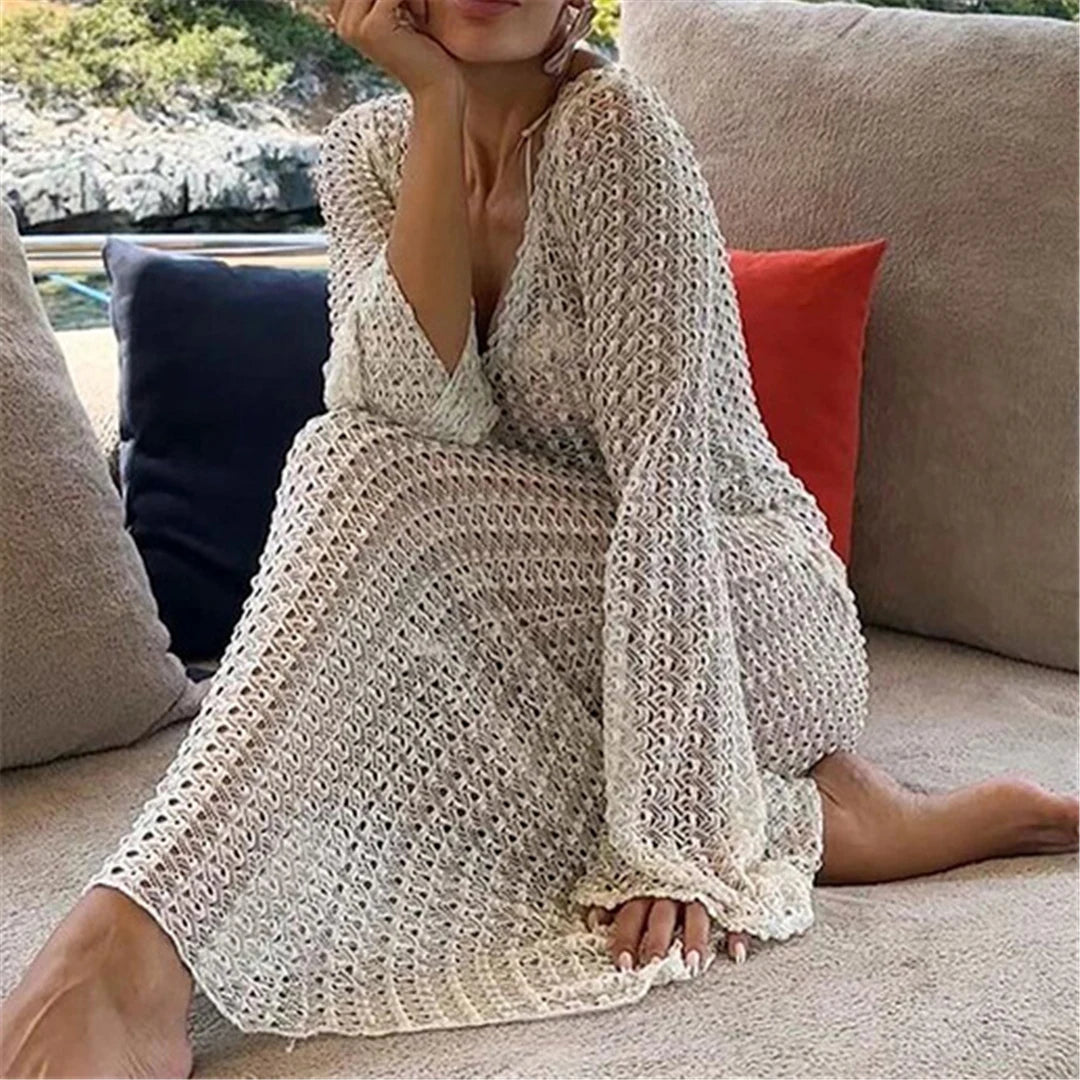 Elegant long sleeve crochet tunic beach cover-up, ideal for seaside styling. Features a delicate see-through design, crafted from a mix of nylon, polyester, rayon, and cotton. True to size, available in white.