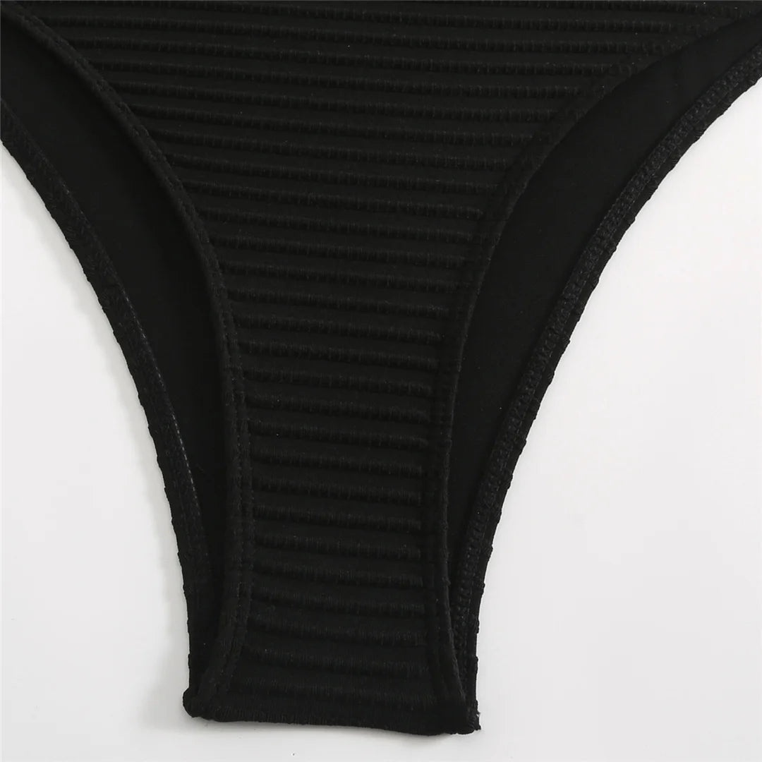 Embrace unique style with a cut out asymmetric one shoulder one piece swimsuit, offering elegance and boldness through its high leg cut design. Featuring strategic cut outs, a padded fit, and adjustable shoulder strap for maximum comfort and support. Made from polyester, spandex, and polyamide, this monochrome solid pattern is ideal for those making a fashion statement on the beach or poolside. Available in black and white.