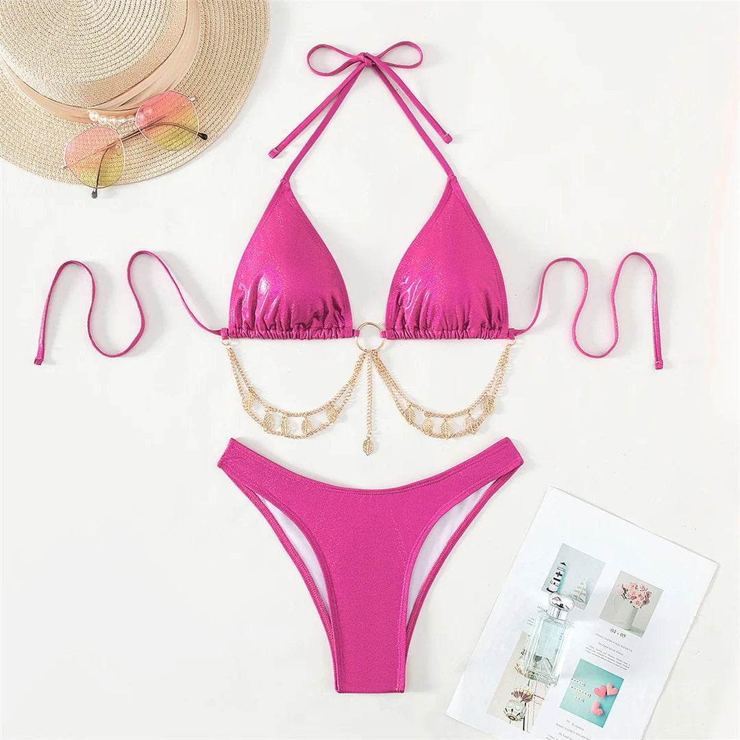 Stunning Two-Piece Brazilian Bikini Set for Women, Featuring Bold Halter Neckline with Metal Chains and Glitter Accents. Solid Hot Pink Swimwear Made from Nylon and Spandex. Low Waist, Wire-Free Support, and True to Size Fit with Padding. Standout Edgy Style for Beach Fashion.