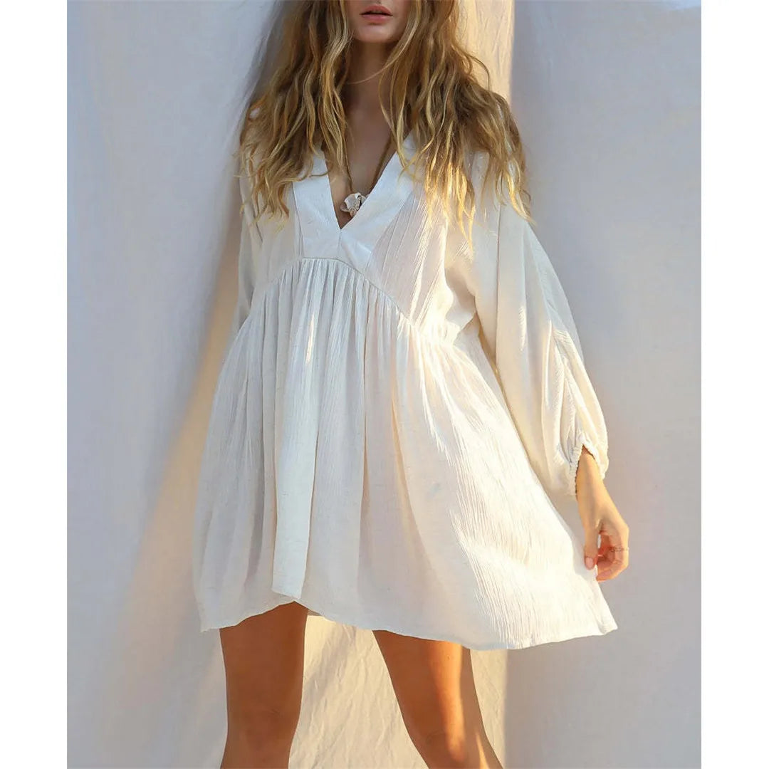Effortlessly chic Long Sleeve V Neck Backless Cotton Tunic in White. This beach cover-up, crafted from cotton, nylon, polyester, and rayon, offers a comfortable relaxed fit. Featuring a backless design, V-neck front, and long sleeves, it provides both sophistication and sun protection. Fits true to size, this solid beach dress is perfect for a day of seaside lounging or a casual stroll along the shore.