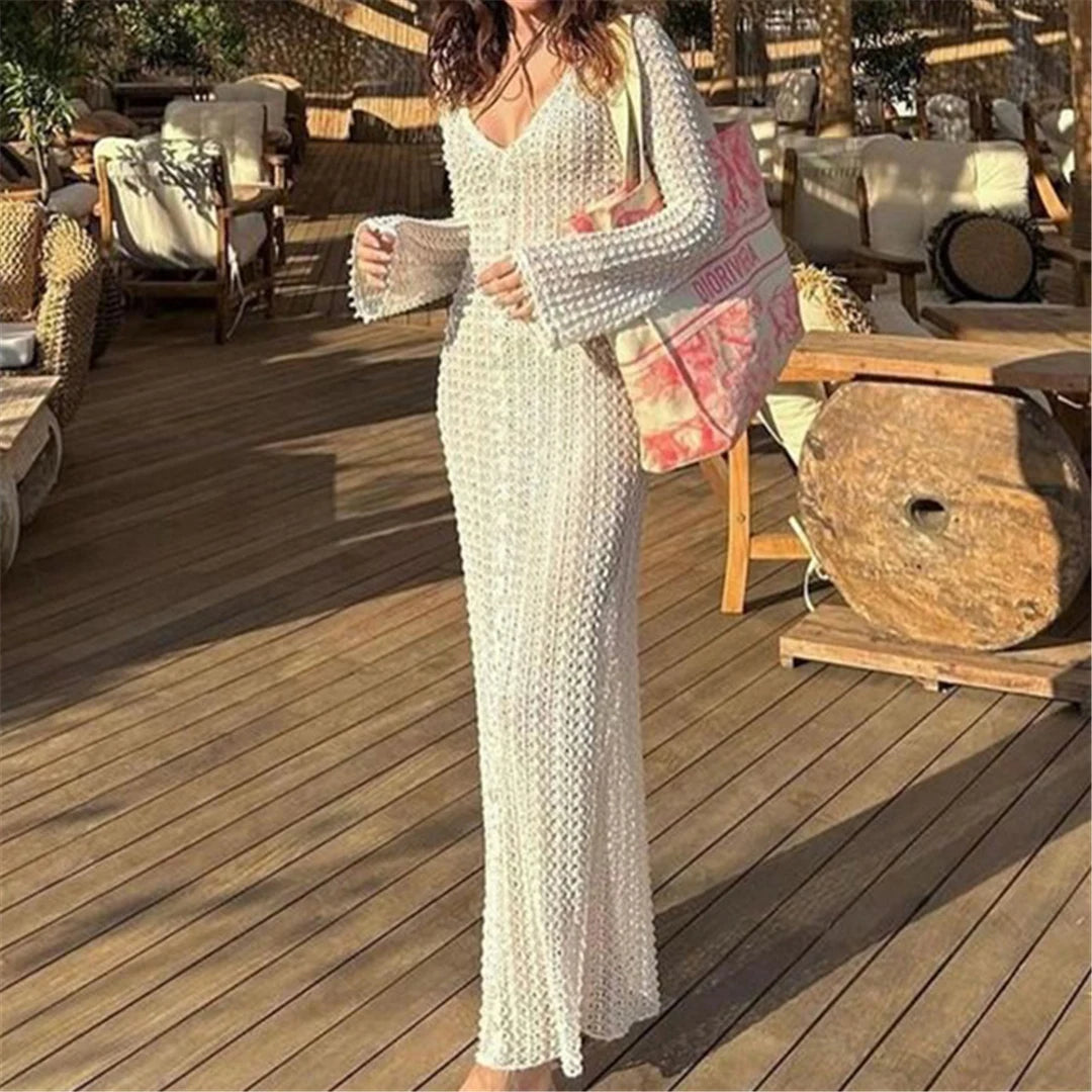 Elegant long sleeve crochet tunic beach cover-up, ideal for seaside styling. Features a delicate see-through design, crafted from a mix of nylon, polyester, rayon, and cotton. True to size, available in white.
