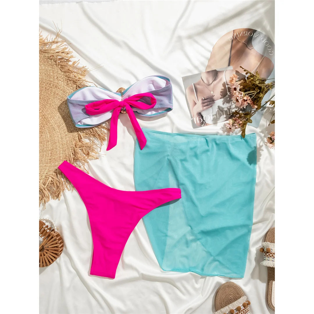 Bandeau with Skirt Splicing Bikini Set, a three-piece swimwear ensemble available in sizes S to L. Made of Nylon and Spandex, featuring a playful patchwork pattern. The bandeau top and splicing skirt offer a fresh and chic look for any waterside setting. Wire-free and low waist design for comfort and ease. Available in Lake Blue Pink, Lake Blue, Pink, and Multicolor. Perfect for those who cherish both style and variety in their swim attire.