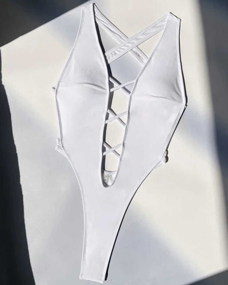Dare to be bold in our Deep V Neck Mini Thong One Piece Swimsuit for Women. This flirtatious monokini, available in sizes S to XL, features a plunging V-neckline, a cheeky mini thong back, and a stylish cross-back design. The swimwear&#39;s high-leg cut offers an elongated, statuesque silhouette. Crafted from durable and comfortable solid-colored Nylon and Spandex material. Available in classic White and Black colors. Ideal for adults aged 18-35. Free shipping available.
