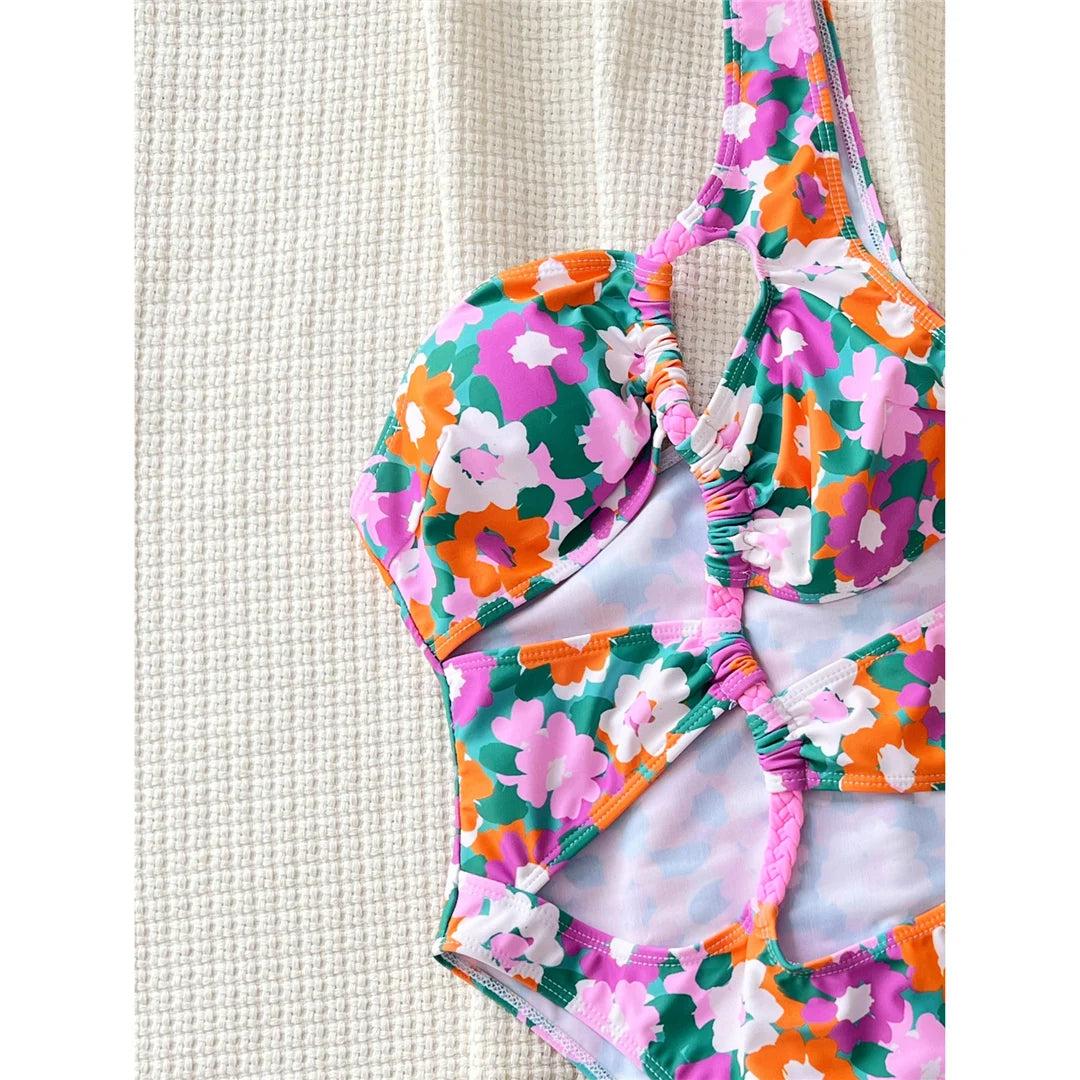 Flowers printed asymmetric cut-out one-piece swimsuit, one-shoulder high-cut design, adjustable triangle top, polyester spandex blend, women's swimwear with vibrant floral prints.