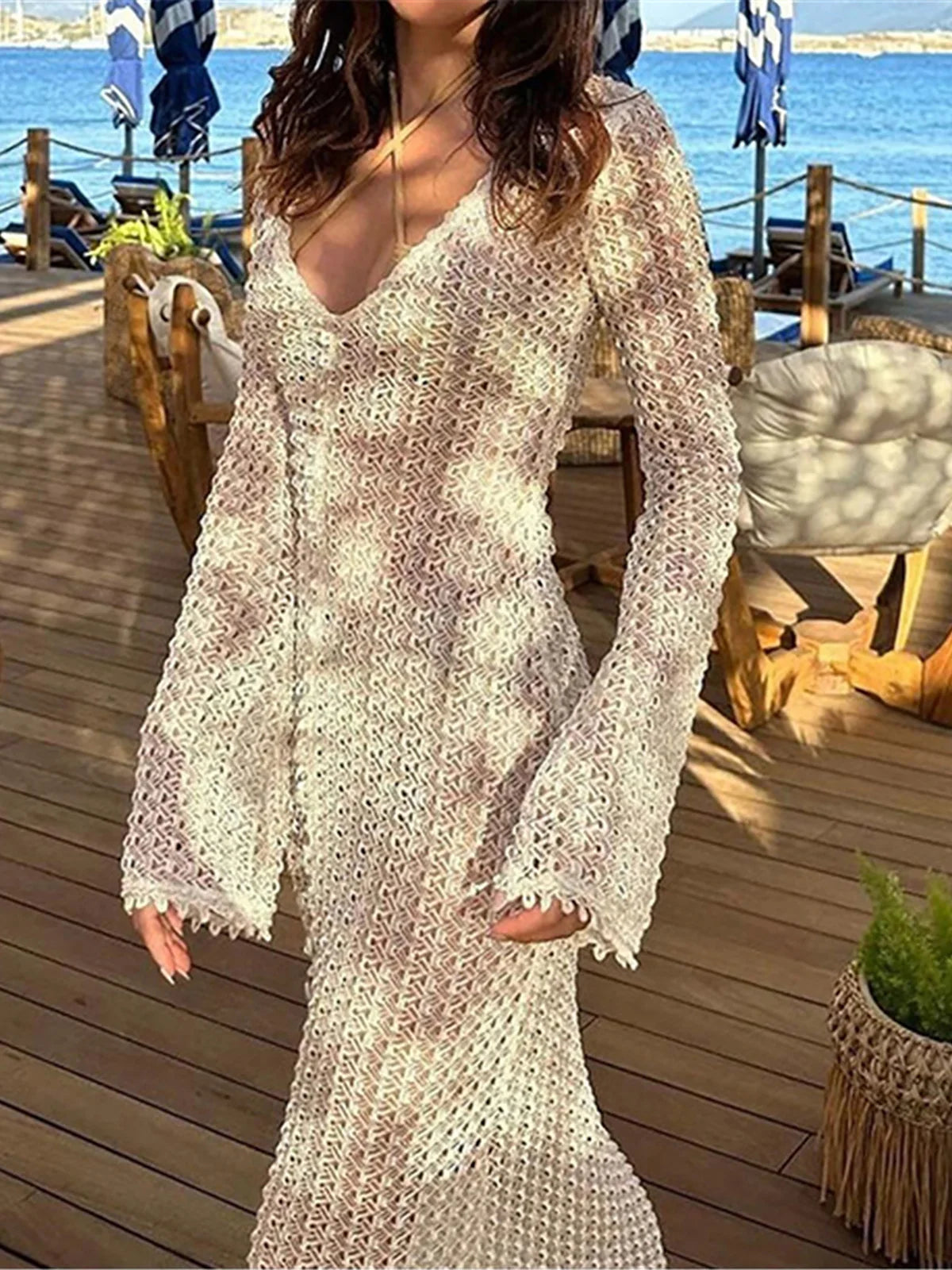 Elegant long sleeve crochet tunic beach cover-up, ideal for seaside styling. Features a delicate see-through design, crafted from a mix of nylon, polyester, rayon, and cotton. True to size, available in white.