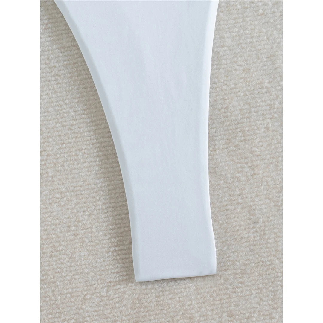 Deep V neck one piece swimsuit in solid white with mini micro thong, high cut design, and adjustable straps for women.