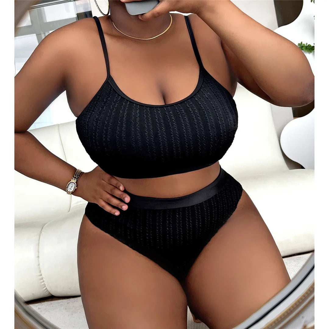 Contemporary ribbed two-piece bikini set for women available in sizes 0XL to 4XL. Perfect for a modern beach look, this high-waisted bikini, crafted from high-stretch nylon and spandex, features a solid pattern, wire-free support, and padding. This essential summer wardrobe piece in Black ensures style, confidence, and comfort for all seasons.