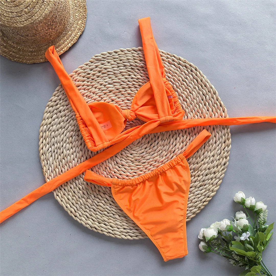 Tie dye flowers bikini set with floral accents and high leg cut in green, orange, and yellow.