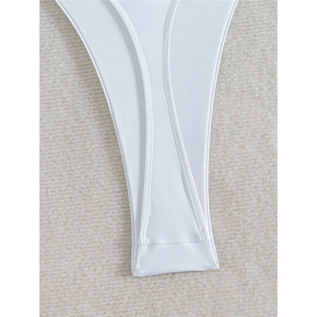 Deep V neck one piece swimsuit in solid white with mini micro thong, high cut design, and adjustable straps for women.