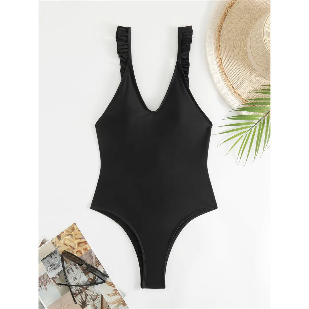 Feminine One-Piece Monokini for Women, Features a Deep V-Neckline with Playful Ruffles, High Leg Cut, and Backless Detail, Crafted from Nylon and Spandex in Solid Black, Fits True to Size, Perfect for Beach Days and Poolside Lounging.