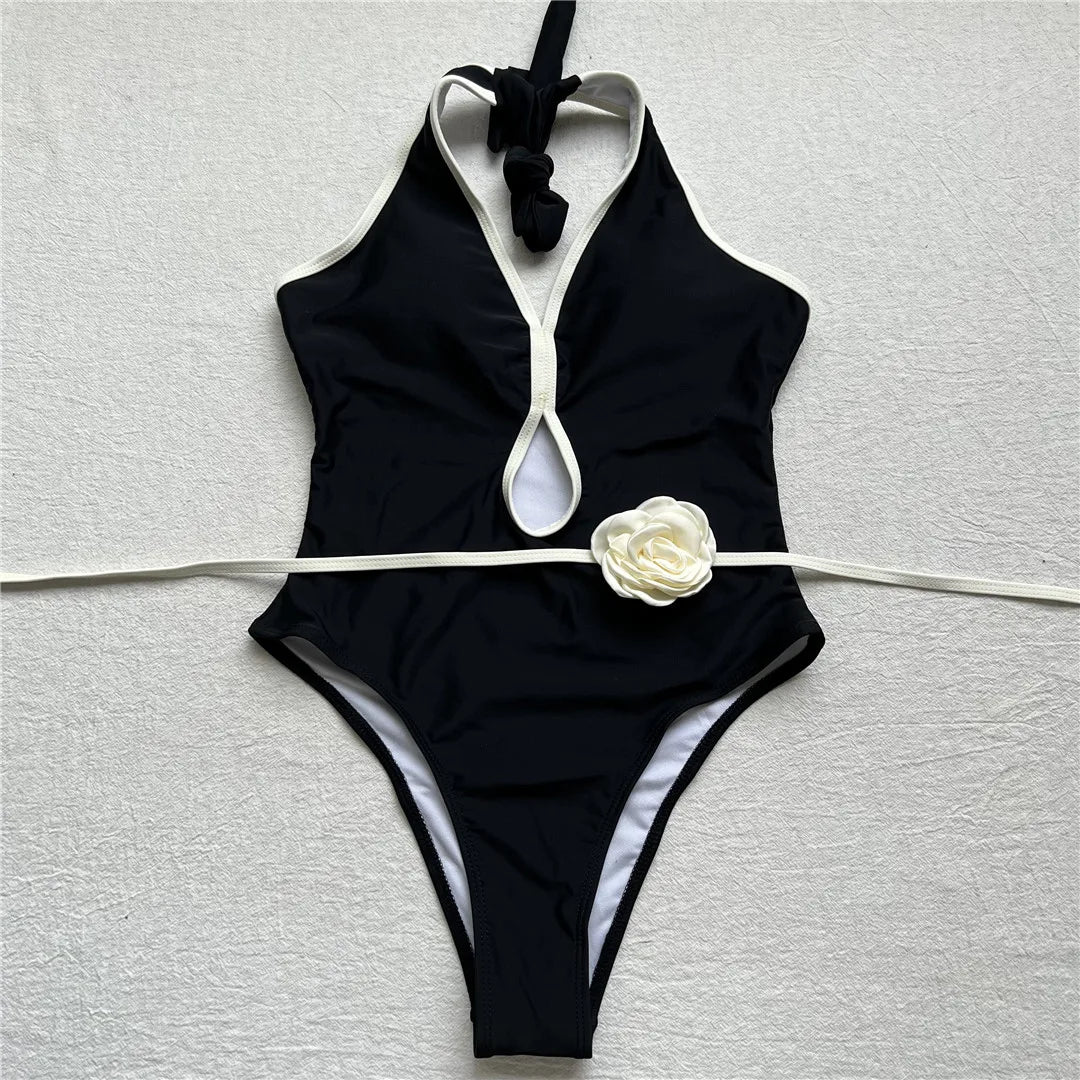 Embrace elegance with an exquisite splicing halter one piece swimsuit featuring backless design and 3D flower belt detailing. Perfect for those who value style and comfort, this monochrome patchwork monokini is made from polyester, spandex, and polyamide, with adjustable shoulder straps and supportive pads. Ideal for women's beachwear collection, available in classic black and white colors.