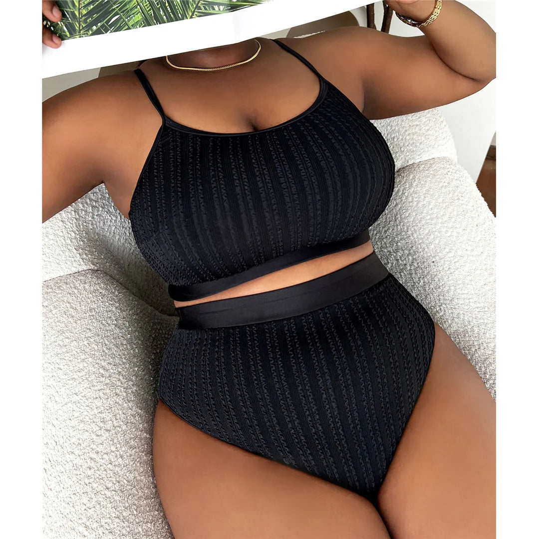 Contemporary ribbed two-piece bikini set for women available in sizes 0XL to 4XL. Perfect for a modern beach look, this high-waisted bikini, crafted from high-stretch nylon and spandex, features a solid pattern, wire-free support, and padding. This essential summer wardrobe piece in Black ensures style, confidence, and comfort for all seasons.