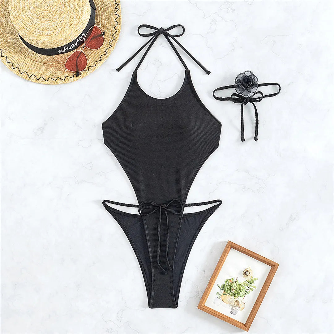 Elegant Ribbed One-Piece Swimsuit for Women with Unique 3D Flower Necklace Detail, Backless Halter Style Made from Nylon and Spandex, Offers Wire-Free Support and True-to-Size Fit, Comes in Sophisticated Solid Black, A Flattering Choice for Beachside Elegance.