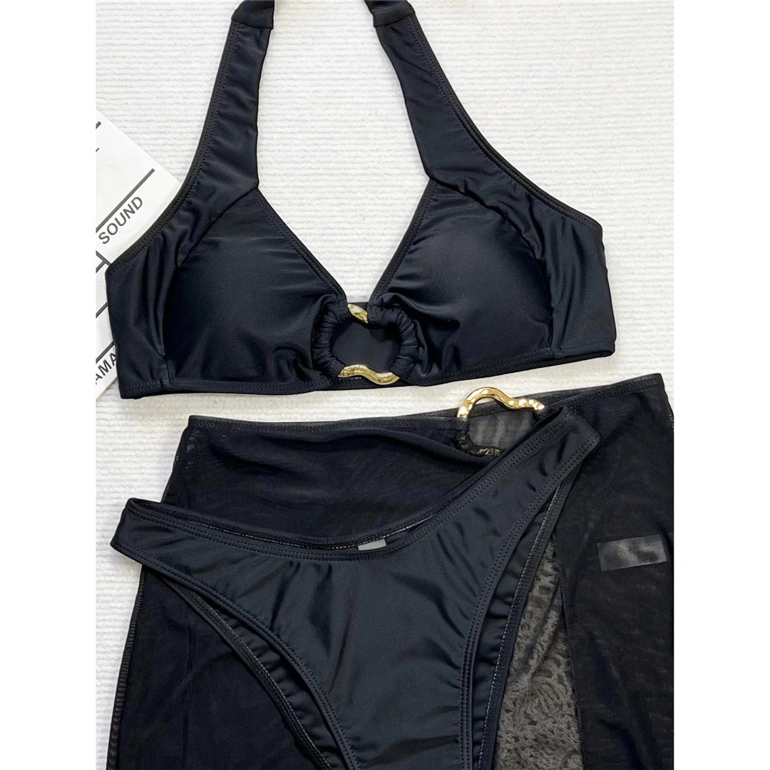Chic halter bikini three-piece set with Brazilian cut and matching skirt in solid black, crafted from polyester and spandex.